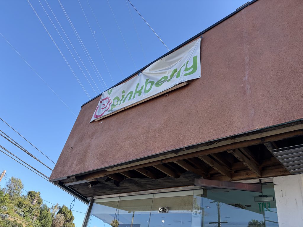 茶色い外壁にPinkberryの緑色の看板が掲げられた店舗の外観
