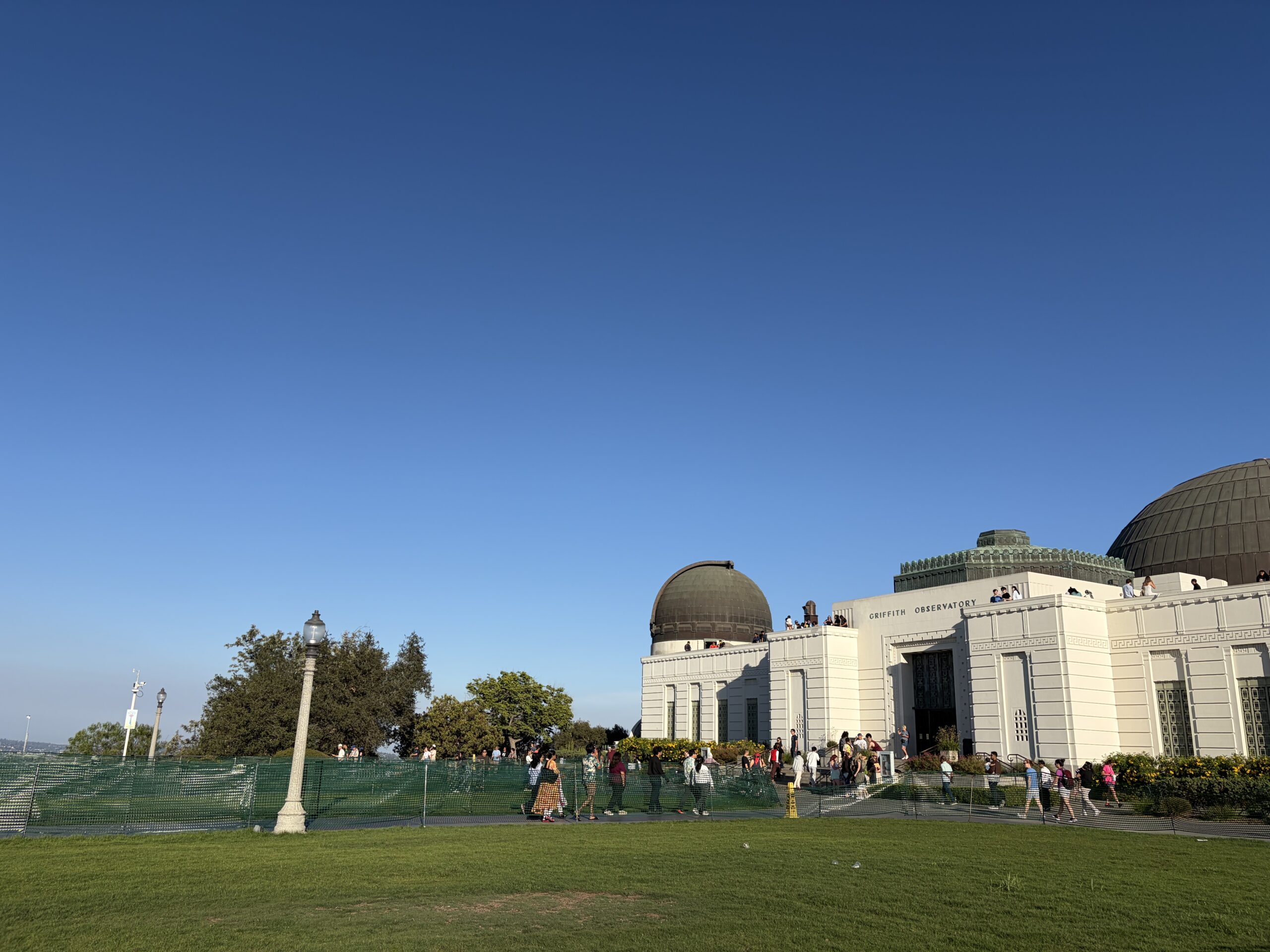 青空の下に建つグリフィス天文台の外観と広がる芝生